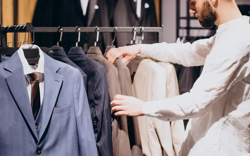 A man choosing a bespoke suit - learn how to choose the perfect location for your franchise with Pearce Bespoke.