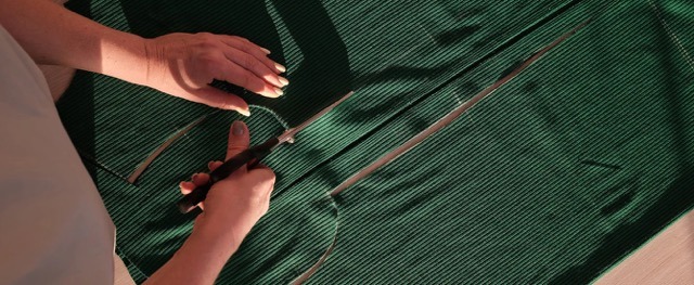 A woman cutting a panel out of green fabric that will be used by Pearce Bespoke Washington DC.