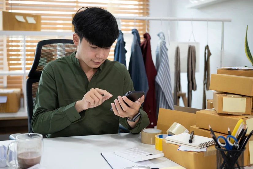 An image of a man looking at his phone - Embracing Technology and Innovation in Your Bespoke Suit Franchise with Pearce Bespoke 