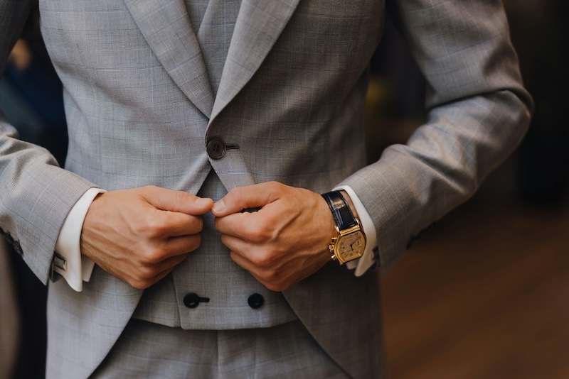 A man holding the lapels of his suit - Learn about custom clothing fit tips