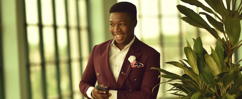 A man in a maroon suit with a snazzy shirt made by Pearce Bespoke.
