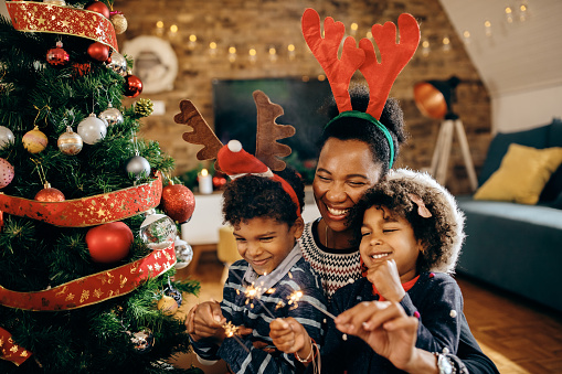 A family sitting at a Christmas tree.