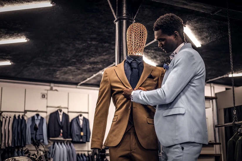 A man wearing a custom suit, altering a suit on a mannequin - Successful Marketing Strategies for a Custom Suit Franchise with Pearce Bespoke 