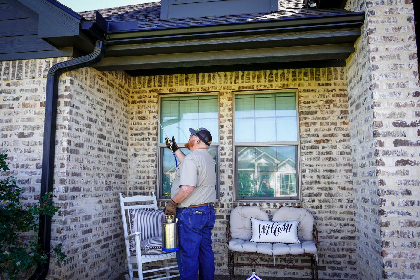 A GGA Pest Management technician looking at the windows to a home.