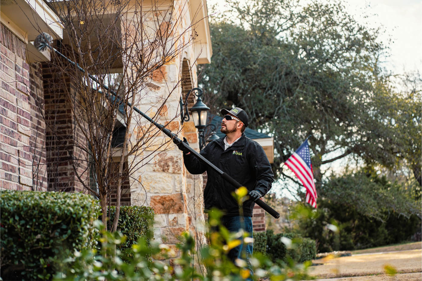 A GGA Pest Management professional clearing pests from the exterior of a home.