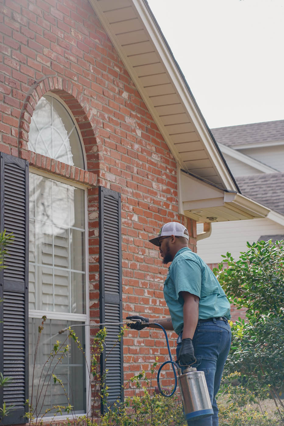 A (fran_brand_short} team member working hard outside of a residential home.