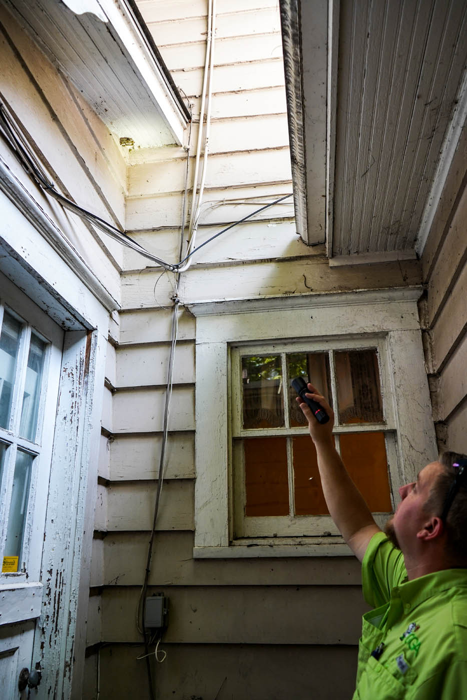 A rat exterminator inspecting a home for gaps.