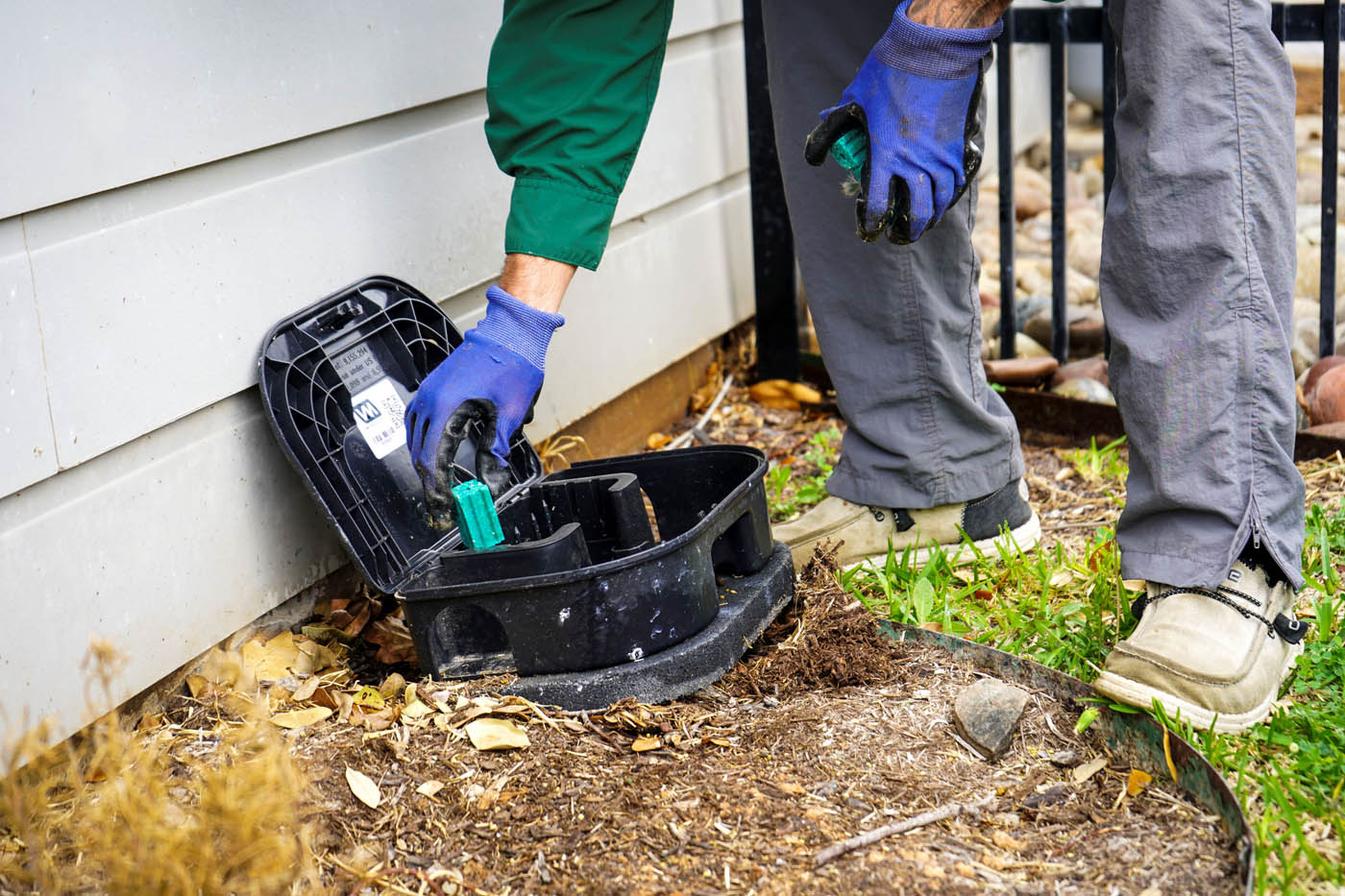 A GGA technician performing pest management services with a trap box.