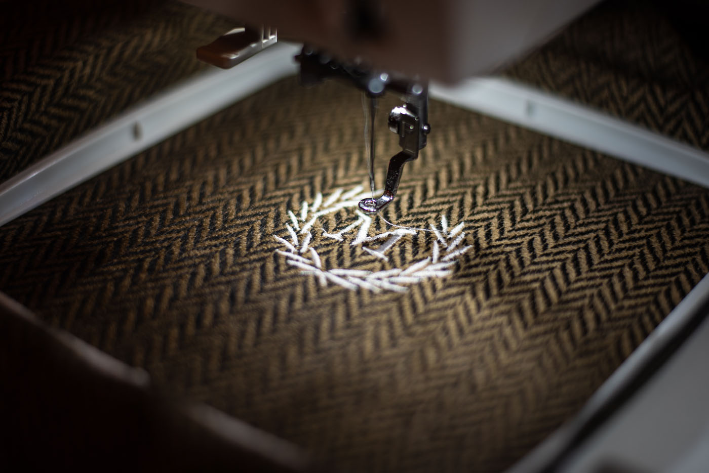 A brand logo being embroidered on fabric - Pearce Bespoke offers custom branding services.