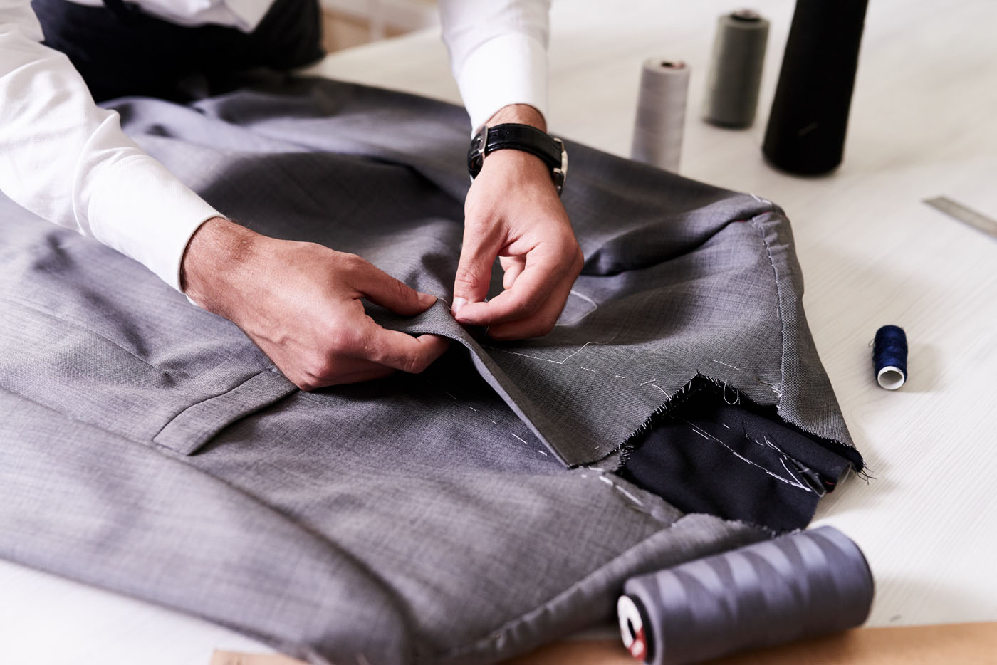 A Pearce Bespoke tailor working on a custom suit.