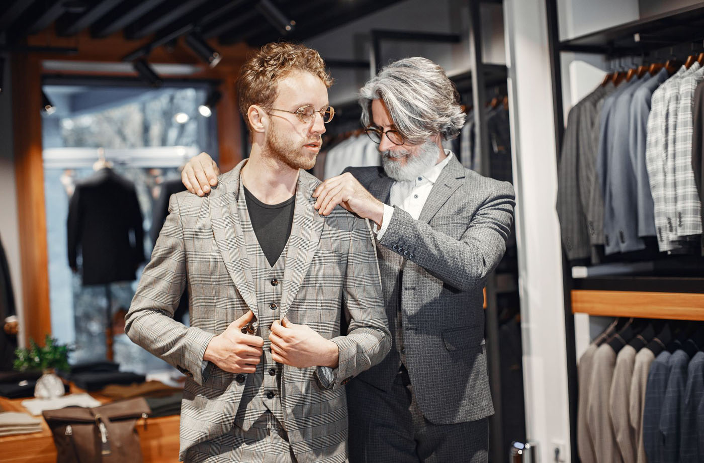 A tailoring fitting a man in a custom suit - view our custom tailoring lookbook for more inspiration.