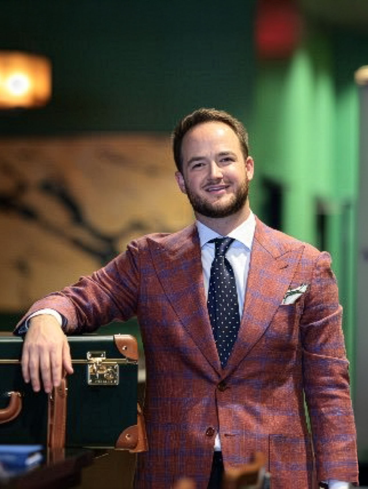 Owner and founder Nathan Pearce standing next to a custom suit.
