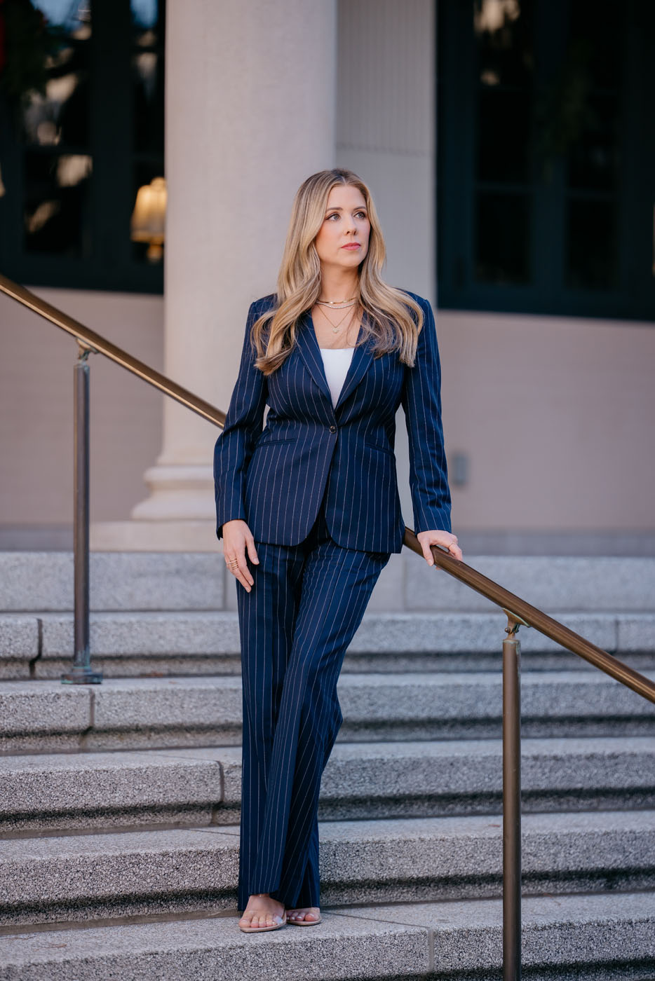 A woman in a stunning stripped, blue custom suit created by Pearce Bespoke.